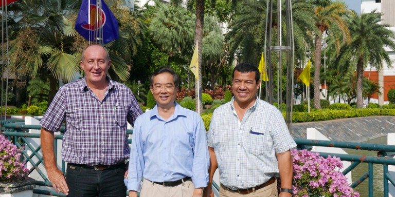 Three men, smiling, outdoors