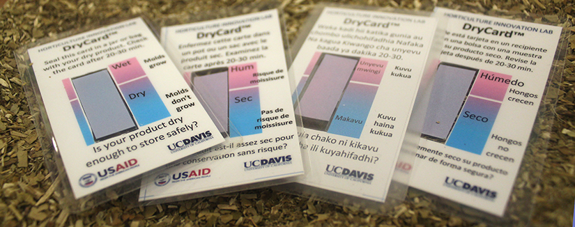 "Is your product dry enough to store safely?" UC Davis logo, four DryCards in English, Swahili, French and Spanish