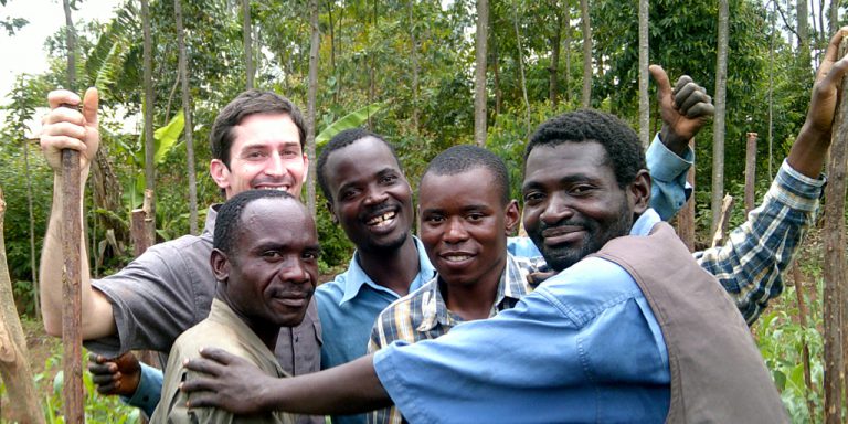 group of agricultural researchers, smiling in a field