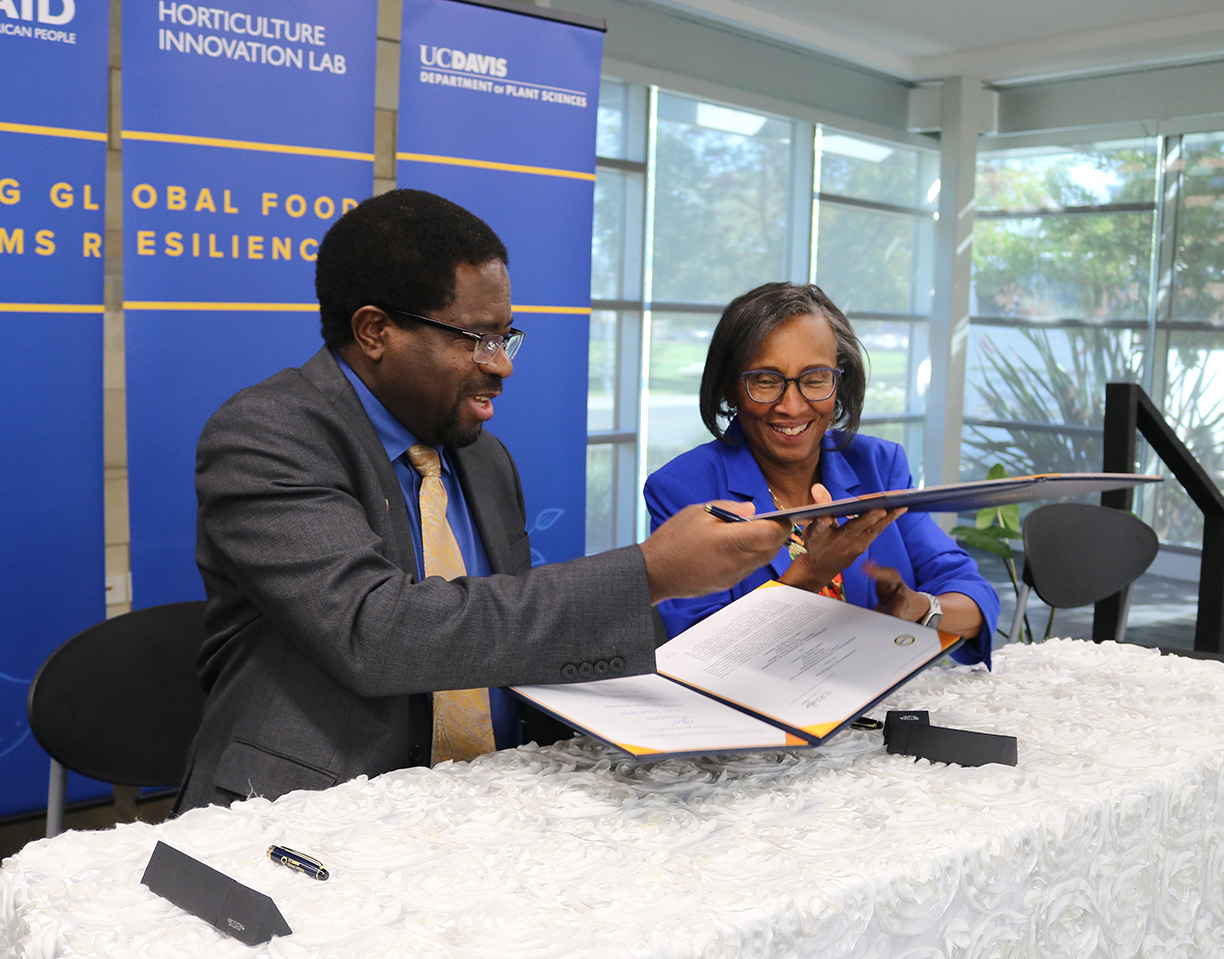 Two people signing Memorandum of Understanding