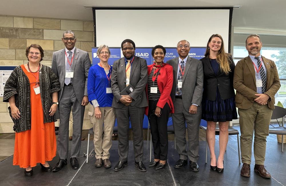 Group photo of speakers on a stage smiling