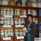 Young man holds jar of seeds and drying beads in vegetable seed repository in Nepal.