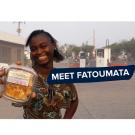 "Meet fatoumata" on a photo of fatoumata holding her packaged dried pineapple, smiling