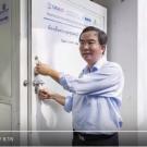 Poonpipope "Poon" Kasemsap opens door to cold room with USAID Hortiulture Innovation Lab logos on it